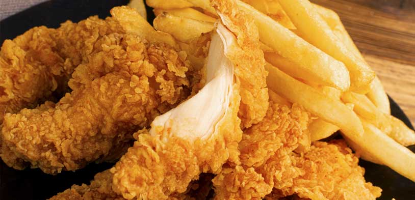 basket of golden chicken tenders with a side of french fries