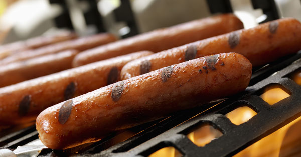 hot dogs with grill marks on a grill above fire