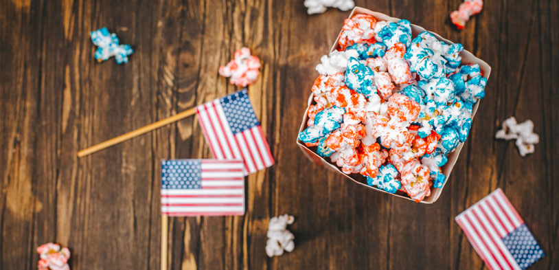 little american flags on table with red white and blue popcorn