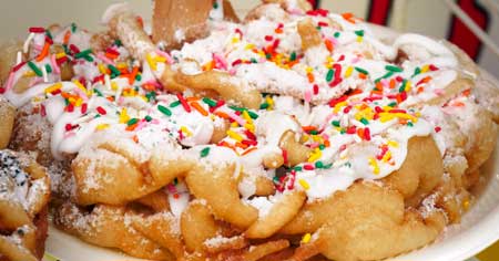 Regular funnel cake with whipe cream and sprinkles as a topping.