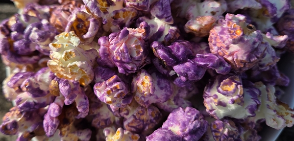 Close-up of popcorn coated in Blueberry Lemon Poundcake glaze, featuring vibrant blueberry color and a sweet blend of juicy berries, zesty lemon, and pound cake dessert flavor
