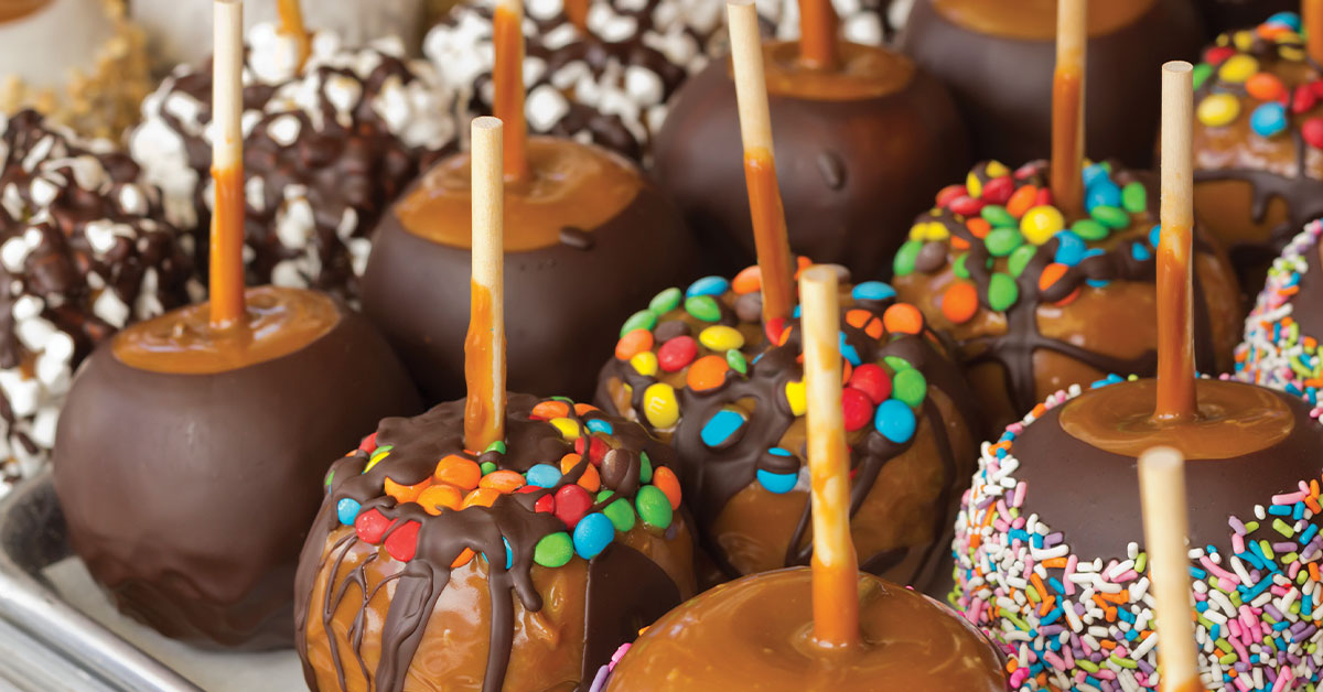 chocolate-covered caramel candy apples with candy and sprinkles