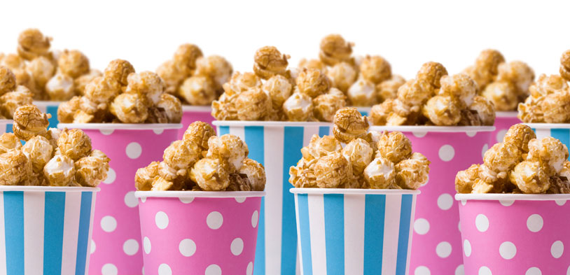 Pink and blue cups arranged in three rows holding caramel corn. Pink and blue cups arranged in three rows holding caramel corn.