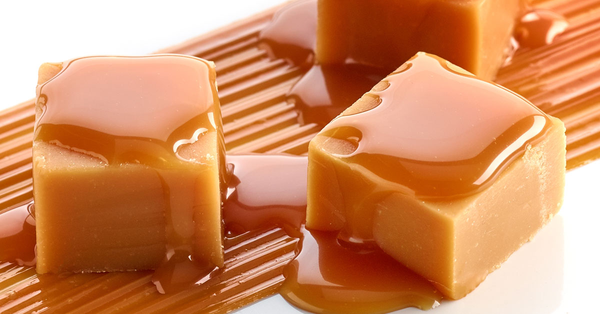 caramel-flavored candy cubes with caramel syrup on textured caramel