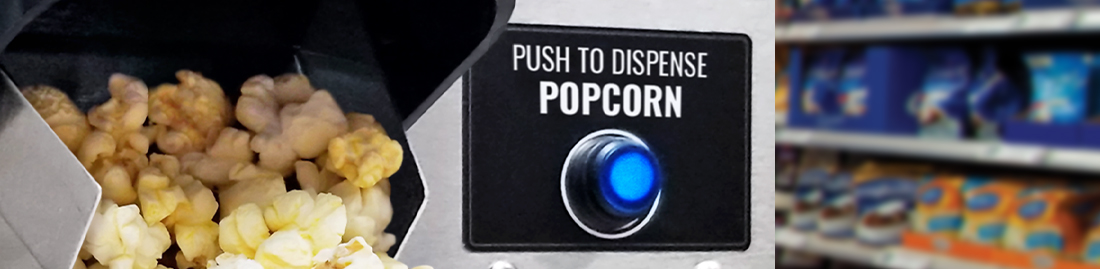 Close up view of popcorn dispensing chute and three popcorn machines