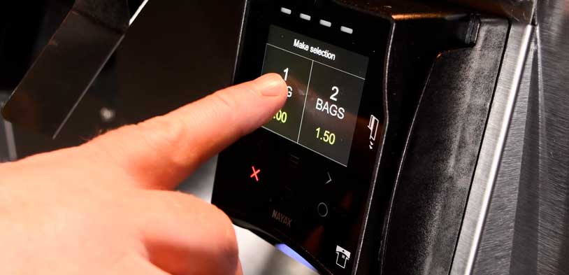 Finger selects option on digital screen before making a cashless purchase from vending machine