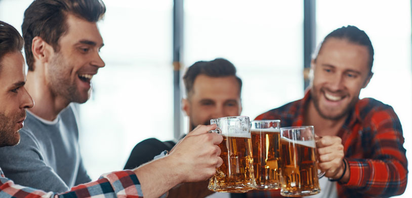 friends smile and toast with their beers