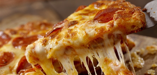 cheesy pepperoni slice being pulled from pizza with metal pie holder