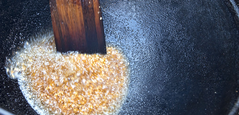 Kettle Corn in oil in a large kettle cooking.