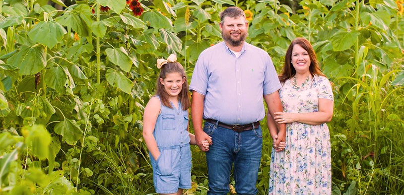 The family that owns Amazing Grace family farm standing outside in the farm.