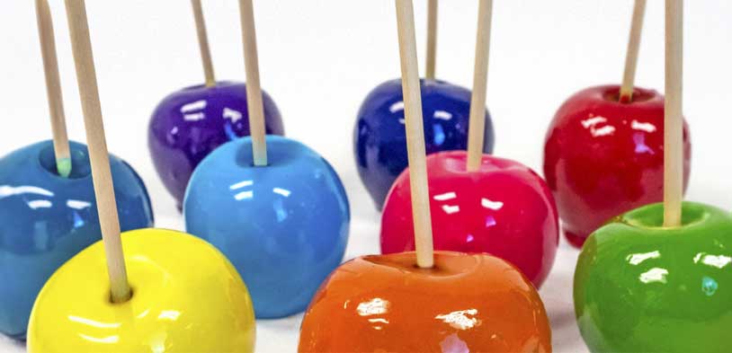 rainbow colored candy apples on a white background
