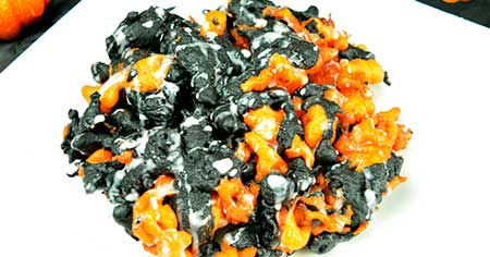 Funnel cake that is dyed multiple colors and fried together with whip cream on top.