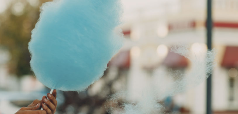 a hand is shown holding cotton candy in the streets