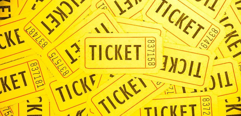 yellow tickets lay on one another in a pile