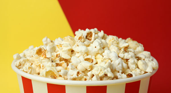 Popcorn tub in front of a multi-colored background of red and yellow