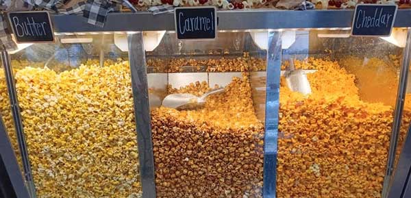 a display case of gourmet popcorn flavors including butter, caramel, and cheddar