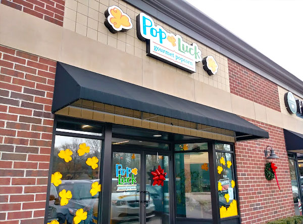 The front of the building for business PopLuck showing their logo and front door.