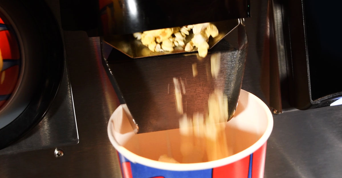 popcorn pouring from readypop series popper dispenser into movie theater butter popcorn tub popcorn puring from readypop series popper dispenser into movie theater butter popcorn tub