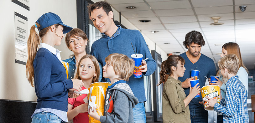 Two families eating popcorn near the concession stand.