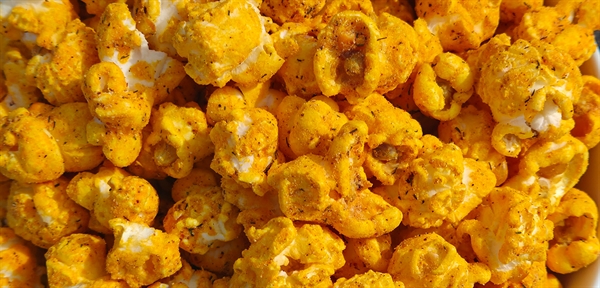 Close-up of popcorn coated in Taco Pickle seasoning, featuring a bold blend of zesty dill pickle and savory taco spices for a tangy, flavorful crunch