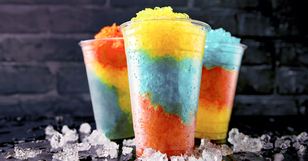 frozen drinks like slushies with multiple flavors on dark background