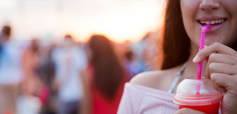 girl on beach enjoys frozen drink
