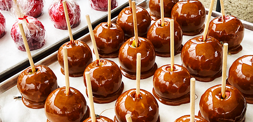 Caramel and Candy Apples on trays for serving and cooling.