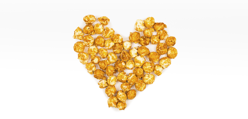 caramel corn isolated on white background in the shape of a heart