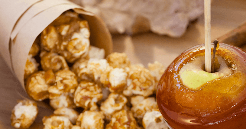 close-up caramel corn spilled on table with caramel apple
