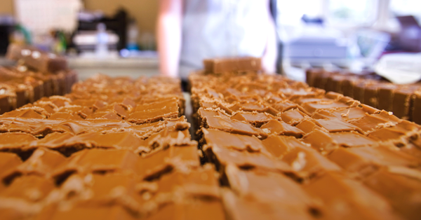 fudge sliced in a grocery store with patrons in the background