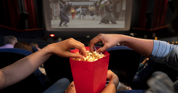 people eating popcorn in movie theater.