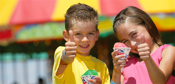 two kids giving a thumbs up while eating snow cones