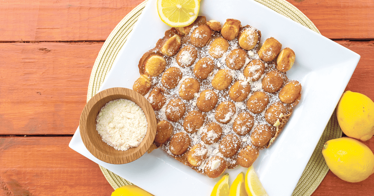 lemon bubble waffle with Signature Shake lemon topping and lemons on a wooden table lemon bubble waffle with Signature Shake lemon topping and lemons on a wooden table