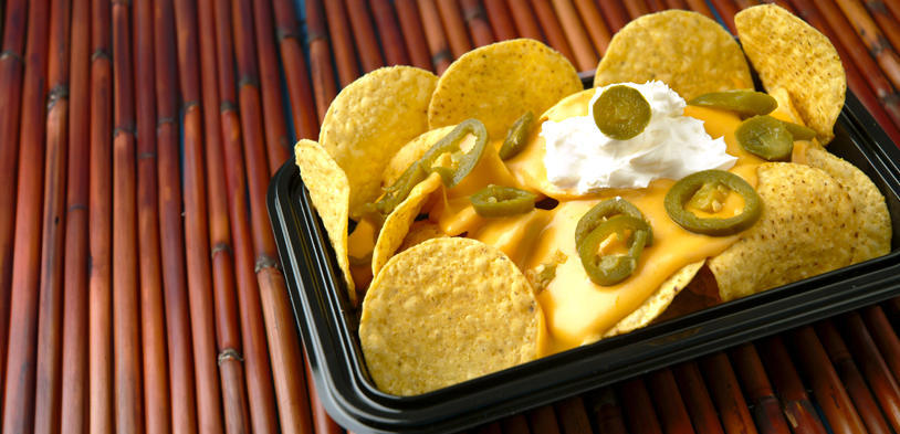 fully loaded nachos on a bamboo table top