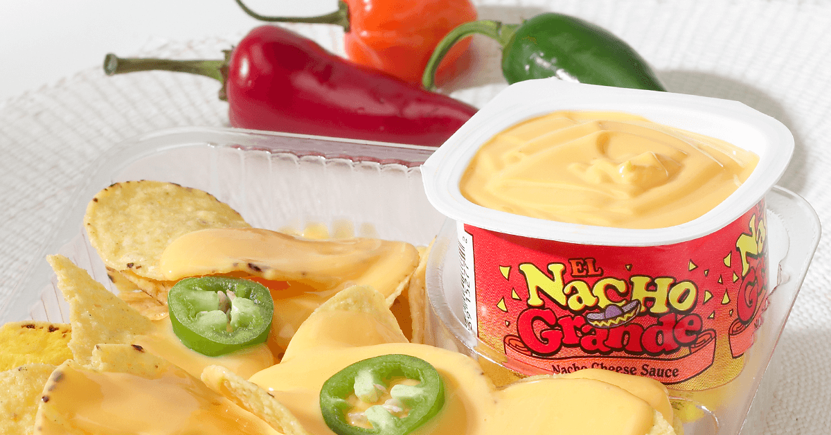 El Nacho Grande brand prepackaged cheese cups and nacho chips in plastic serving tray with jalapenos and peppers El Nacho Grande brand prepackaged cheese cups and nacho chips in plastic serving tray with jalapenos and peppers