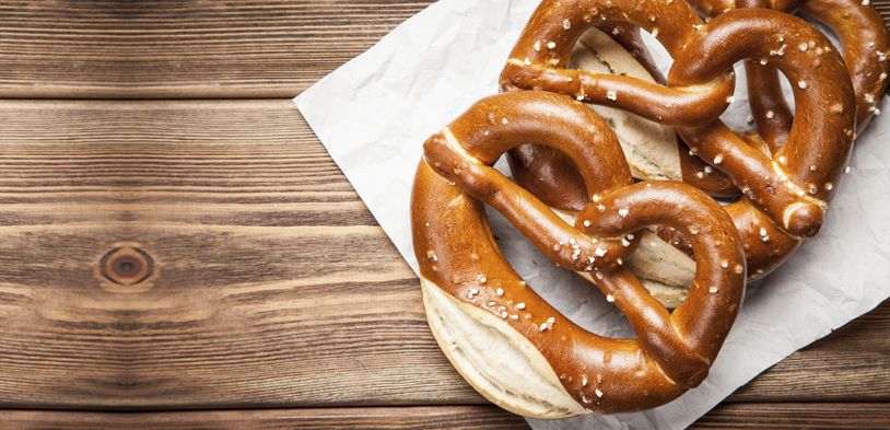 a pretzel wrapped in a napkin on a wood table