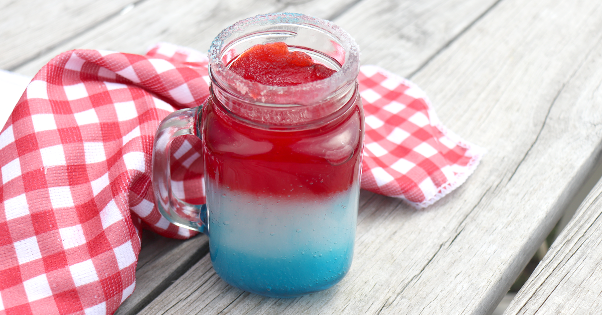a red, white and blue slushie drink on a wooden table.