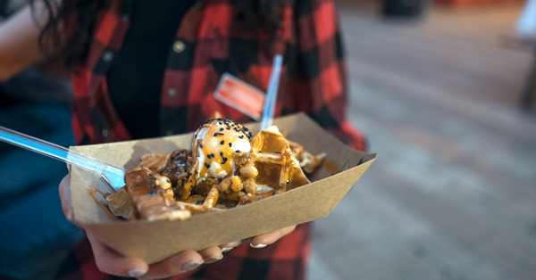 woman holds desert in her hands with bits of waffle cones in it.